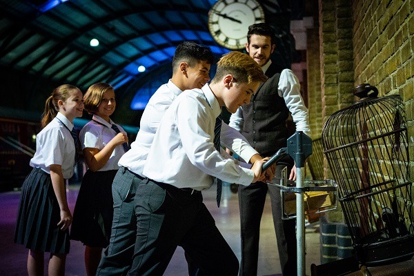 Children pushing the trolley through to Platform 9 ¾